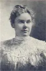 A woman in white dress and hair up.